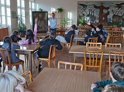 Heimleiter erzählt im Speisesaal vom Hl. Leopold mit Bild